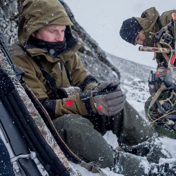 Alpine hunter checking communication device