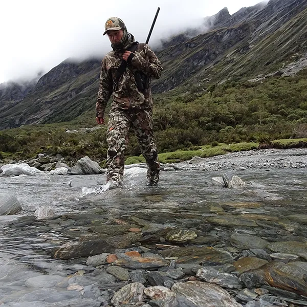 Hunter crossing a shallow river