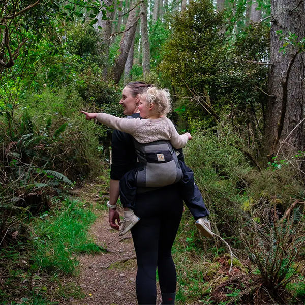 Mother doing a day walk with baby in a carrier on her back