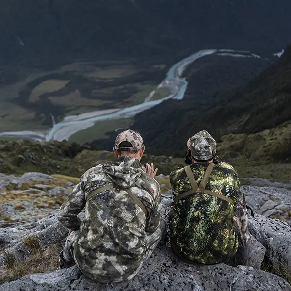 Hunters on a cliff overlooking the valley